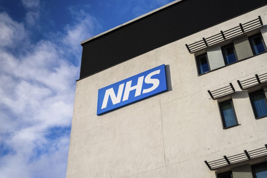 close up of NHS sign on side of building