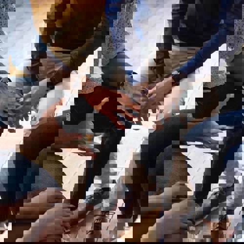 Group sitting in a circle, clear view of their hands and legs.