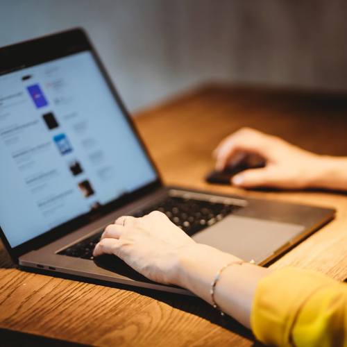 Person In A Yellow Top Using A Laptop