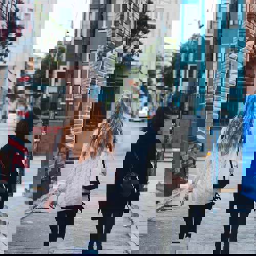 Two women walking down a graffitied street